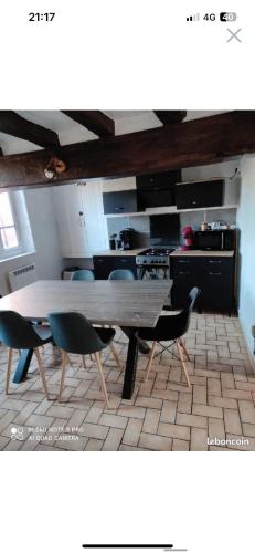 einen Tisch und Stühle in einem Zimmer mit Küche in der Unterkunft Gîte l’échappée belle in La Gollotte
