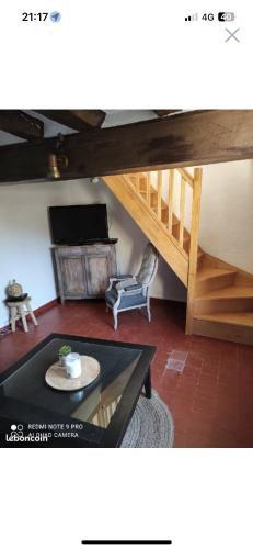ein Wohnzimmer mit einer Treppe und einem Tisch in der Unterkunft Gîte l’échappée belle in La Gollotte