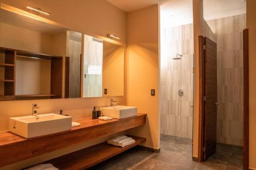 a bathroom with two sinks and a shower at Casa Amelia Puerto Escondido in Puerto Escondido