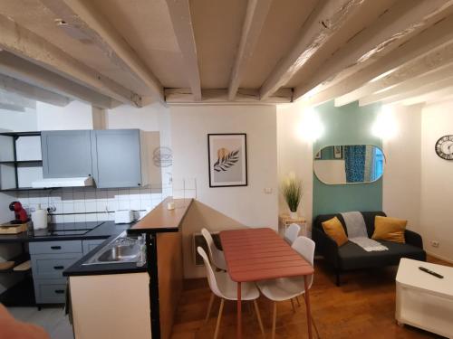 une cuisine et un salon avec une table et un canapé dans l'établissement Green Horizon Château Thierry, à Château-Thierry