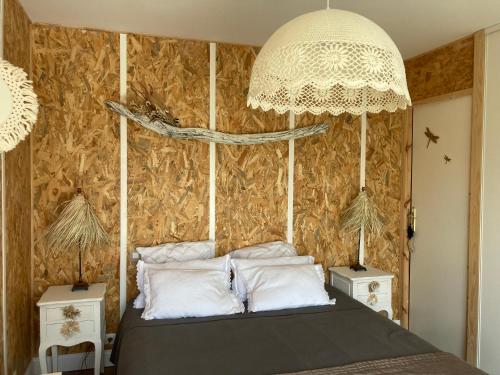 une chambre avec un lit et un lustre dans l'établissement Charmante dépendance, à Arès