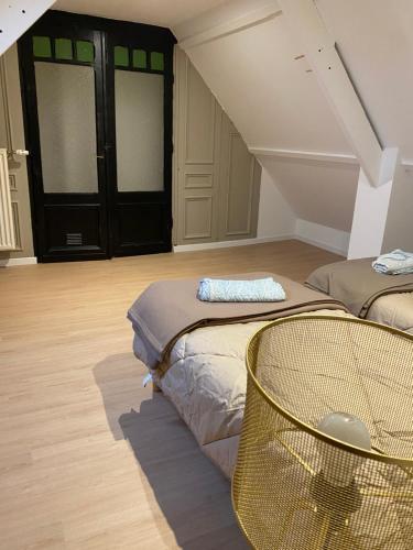 a room with two beds and a chair in it at Family cottage 4 chambres in Bourbourg