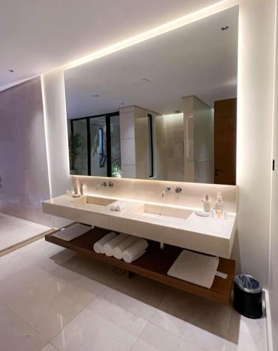 uma casa de banho com um lavatório e um espelho grande em شاليهات نفلة em Hajlah
