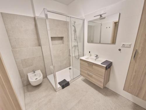 Un baño con ducha, inodoro y lavabo. en VIA Apartmany, en Trenčín