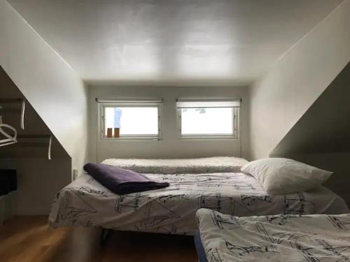 a bedroom with two beds and a window at Lilla Gäststugan in Uppsala