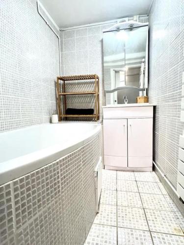 a white bathroom with a tub and a sink at Maison cocooning à 6 mn de Honfleur in La Rivière-Saint-Sauveur