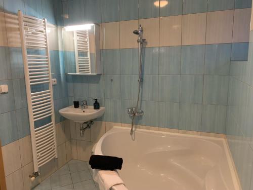 y baño con bañera y lavamanos. en Home - Ostružina en Olomouc