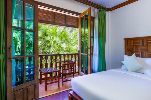 a bedroom with a bed and a balcony at Pierre Hotel in Siem Reap