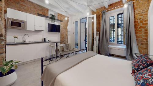 Cet appartement comprend une chambre avec un lit blanc et une cuisine. dans l'établissement La Casetta in colonne, à Milan