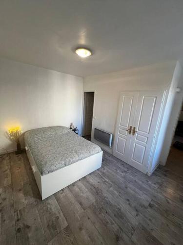 ein Schlafzimmer mit einem Bett und einer weißen Tür in der Unterkunft Appartement tout équipé proche plages in Fos-sur-Mer