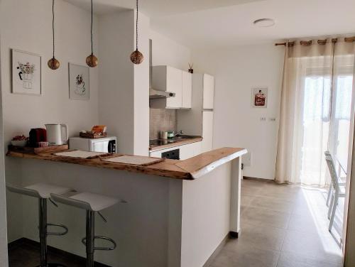 een keuken met een aanrecht en wat krukken erin bij Casa L'agrumeto in Ventimiglia