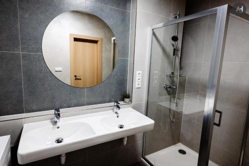 a bathroom with a sink and a mirror and a shower at AH Herberia in Košice
