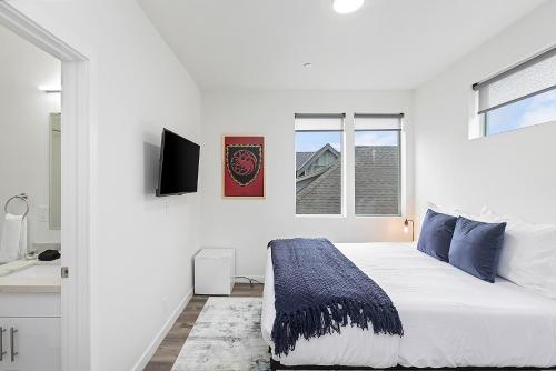 a white bedroom with a bed and a sink at Dreamfyre's Ancient Dragon Horn Sweet Suite in Seattle