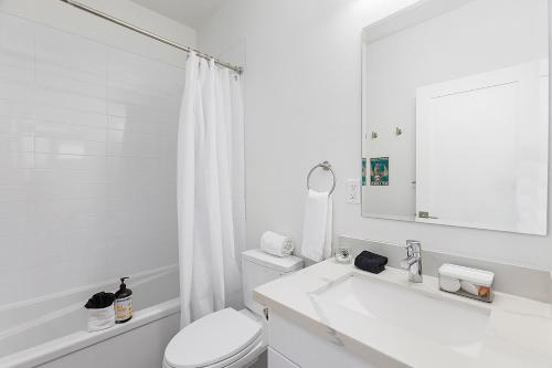 a white bathroom with a toilet and a sink at Dreamfyre's Ancient Dragon Horn Sweet Suite in Seattle