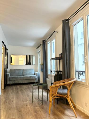 un salon avec un canapé et une chaise dans l'établissement Petit coin de paradis proche Gare de l'Est, à Paris