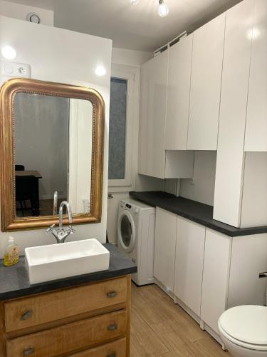 une cuisine blanche avec un évier et une machine à laver dans l'établissement Petit coin de paradis proche Gare de l'Est, à Paris