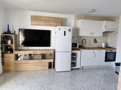 a kitchen with a white refrigerator and a tv at Apartamento OCEAN PEARL in Corralejo