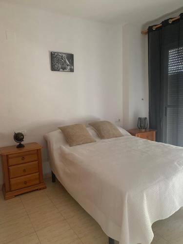 1 dormitorio con cama blanca y mesita de noche de madera en Beau et paisible T4 torrevieja, en Torrevieja