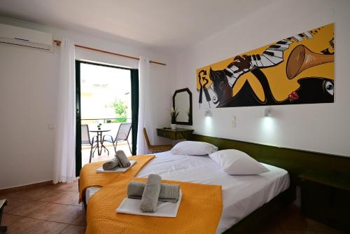 a bedroom with two beds and a large painting on the wall at VILLA CARIATIS in Nea Kalikratia