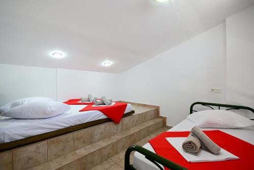 two beds in a room with red and white sheets at VILLA CARIATIS in Nea Kalikratia