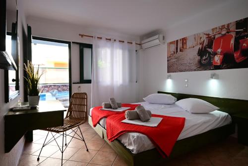 a bedroom with a bed with a red blanket on it at VILLA CARIATIS in Nea Kalikratia
