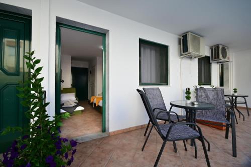 a balcony with a table and chairs and a bedroom at VILLA CARIATIS in Nea Kalikratia