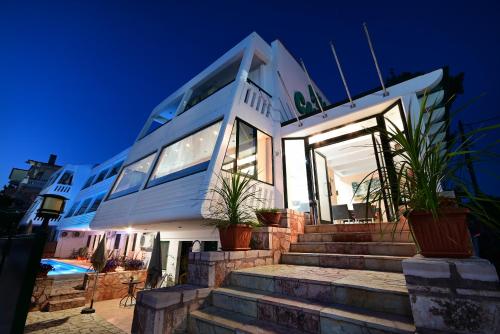 a house with stairs and potted plants in front of it at VILLA CARIATIS in Nea Kalikratia