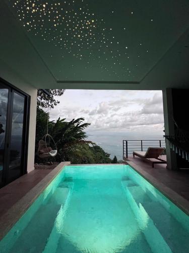a swimming pool in a house with a view of the ocean at SOL e MAR in Uvita