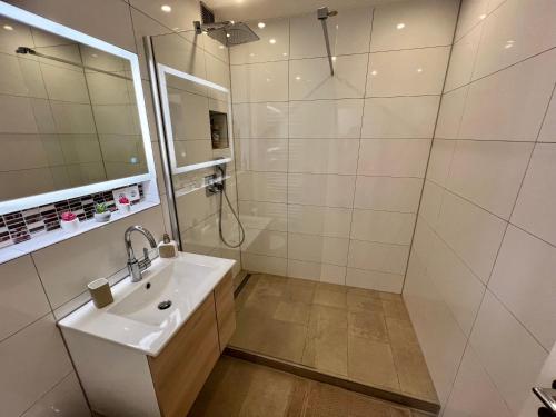 a white bathroom with a sink and a shower at Lilis Apartment mit Balkon in Augsburg