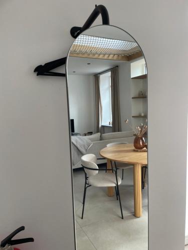 sala de estar con mesa y espejo en L'Apothèque - Résidence Le Cercle, en Marche-en-Famenne