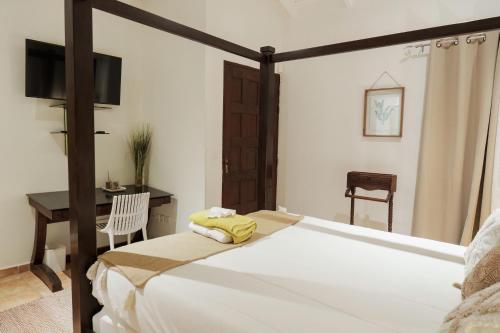 a bedroom with a bed and a desk and a chair at Villa Kapresse du 978 - Guest house in Marigot