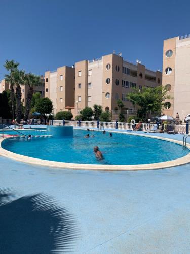 un grupo de personas nadando en una gran piscina en Beau et paisible T4 torrevieja, en Torrevieja