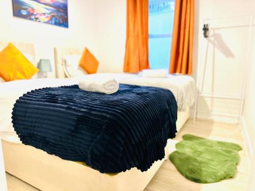 a bedroom with a bed with a blue blanket on the floor at Stylish Dover Apt With Castle View in Kent