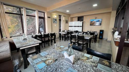 un restaurant avec une salle à manger dotée de tables et de chaises dans l'établissement The Ivory Pine, à Shimla