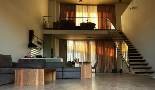 a living room with a couch and a staircase at Villa N40 in Kachretʼi