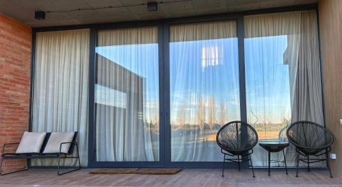 two chairs and a table in front of a large window at Villa #40 in Kachretʼi