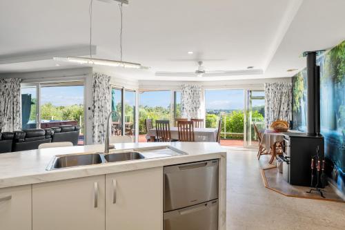 a kitchen with a sink and a living room at RidgeRaj - Kerikeri Holiday Home in Kerikeri