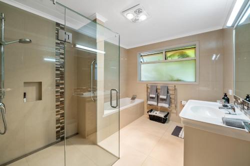 a bathroom with a shower and a sink and a tub at RidgeRaj - Kerikeri Holiday Home in Kerikeri