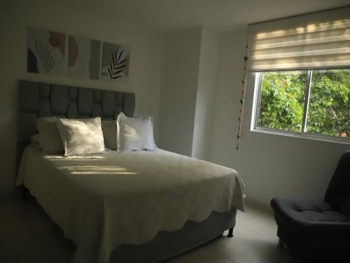 a bedroom with a white bed with a window at Apartamento nuevo, próximo al metro y CC Mayorca in Sabaneta