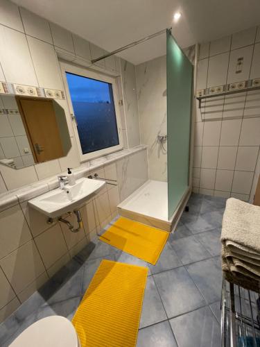 uma casa de banho com um lavatório e um chuveiro com uma janela em Ferienhaus- Dallgow em Dallgow