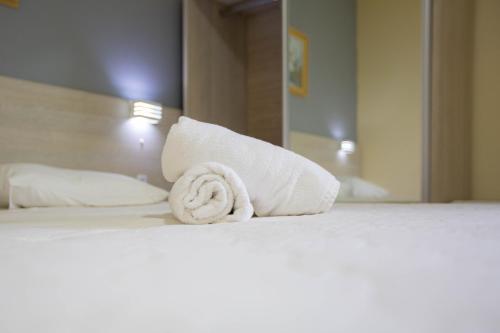 a rolled up towel on a bed in a hotel room at Hotel Vila Mar in Florianópolis