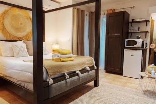 a bedroom with a four poster bed and a microwave at Villa Kapresse du 978 - Guest house in Marigot