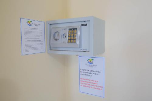 a microwave oven on a wall with two signs at Hotel Vila Mar in Florianópolis