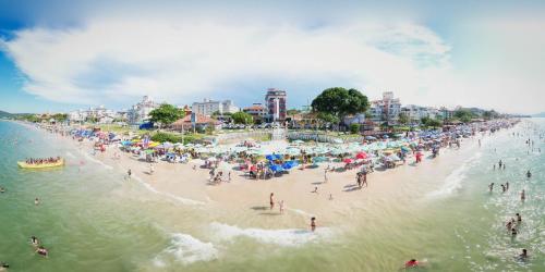 un grupo de personas en una playa en el agua en Hotel Vila Mar, en Florianópolis