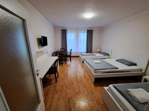 a room with two beds and a table and a couch at Apart Sudenburg / Magdeburg in Magdeburg