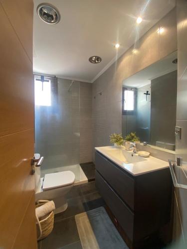 a bathroom with a sink and a toilet and a mirror at Dúplex Markina Xemein in Marquina