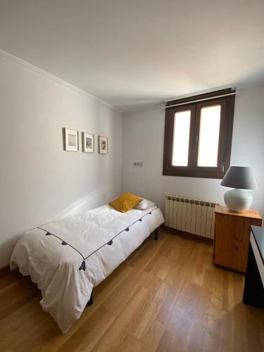a bedroom with a bed and a table and a window at Dúplex Markina Xemein in Marquina