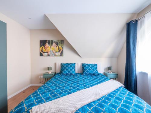 a bedroom with a blue bed with blue pillows at Charmant Cocon au Neudorf in Strasbourg