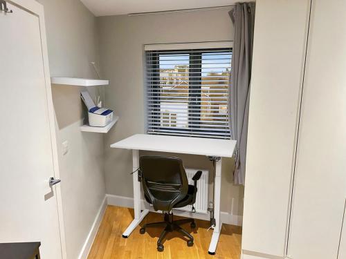 a desk and a chair in a room with a window at Luxury 1 bedroom Apartment in London overseeing Canary Wharf with free parking in London