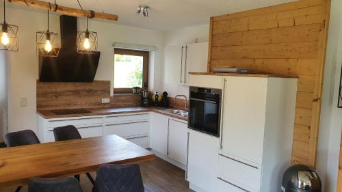 a kitchen with a table and a refrigerator at Chalet Weitsee in Reit im Winkl